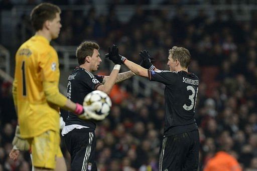 Bayern's Bastian Schweinsteiger (R) congratulates Mario Mandzukic (C) after he scored in London on February 19, 2013